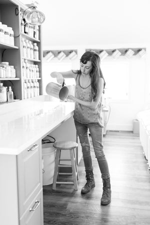 Holly Rutt off the little flower soap co pouring candles in a sunlit studio in chelsea michigan