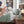 Load image into Gallery viewer, a picture of a mom spraying dragon dreams monster be gone essential oil spray around her kids room as part of the bedtime ritual the bed has a sage green dragon theme 

