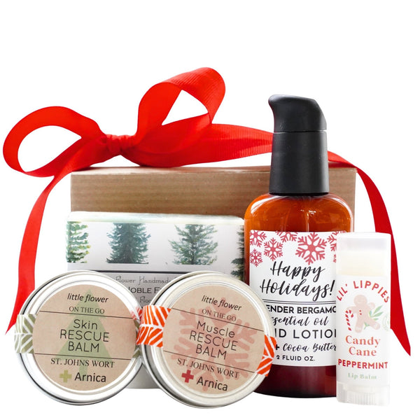 Gift set with skin rescue balms, lotion, and lip balm with a red ribbon on a white background